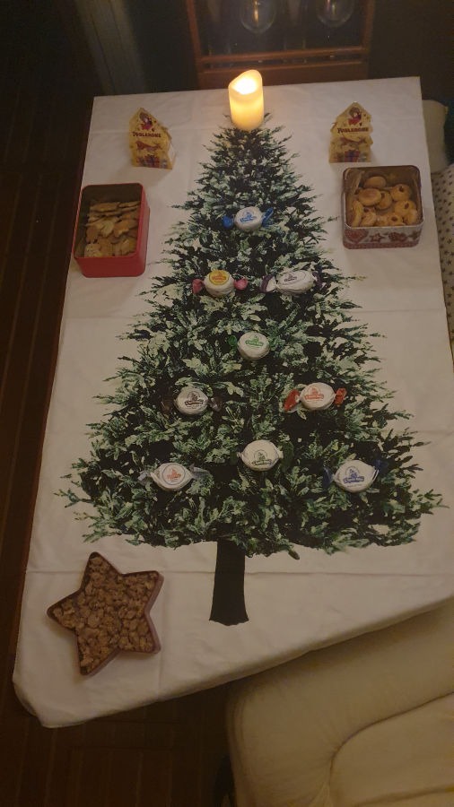 Tisch mit Weihnachtsbaumdecke und Keksdosen